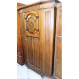 An oak single wardrobe, with carved detailed door and top.