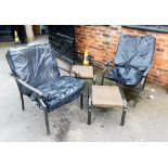 Two metal framed outdoor chairs with footstools and cushions.