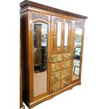 A late Victorian burr walnut triple wardrobe, with fret carved and moulded cornice above two outer g