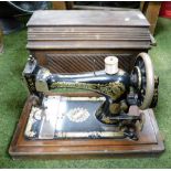 A cased Singer sewing machine, in wooden case.