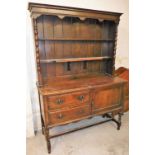 An oak dresser, with plate rack back, on twist column supports with two drawers and single cupboard,