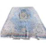 A Chinese carpet, with a design of flowers and leaves, on a pale blue ground with cream borders,