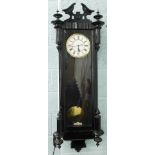 A late 19thC ebonised Vienna wall clock, with a white enamel dial, 114cm high.