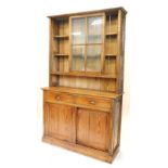 A pine dresser, the raised back with two shelves enclosed by astragal glazed sliding doors, the base