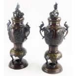 A pair of 19thC Japanese bronze vases and covers, with cast dog of fo finial, each with two ornate