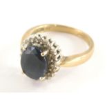 A 9ct gold sapphire and diamond dress ring, sapphire approx .25cts, the central oval cut sapphire