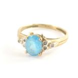 A 9ct gold dress ring, with pale blue oval topaz, in four claw setting, with stepped three stone