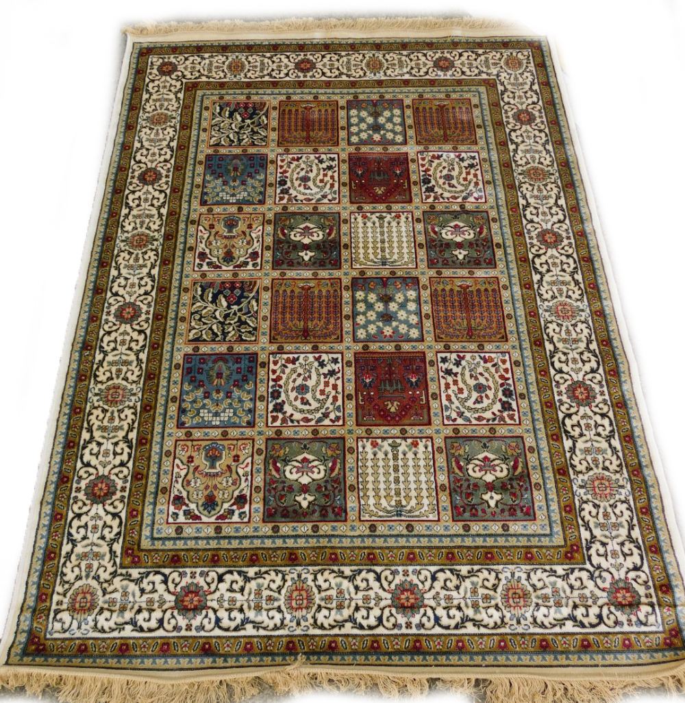 A machine woven mercerised cotton rug, in the Persian style, decorated with flowers, within