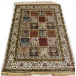 A machine woven mercerised cotton rug, in the Persian style, decorated with flowers, within