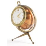 A mid 20thC copper and brass carriage clock, modelled in the form of a globe with revolving stand,