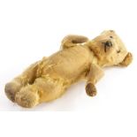 A mid 20thC caramel coloured Teddy bear, with beaded eyes and stitched snout, 36cm long. (AF)