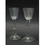 A pair of late 18thC/ early 19thC wine glasses, each with a bell shaped wrythen bowl, and a