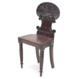 A 19thC mahogany hall chair, with a shell shaped back and solid seat, on turned and reeded legs, (