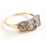 A 9ct gold amethyst dress ring, set with six oval amethysts (1 missing), in claw setting with tiny