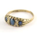 An 18ct gold sapphire and diamond gypsy ring, set with three oval cut sapphires and four tiny