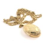 A 9ct gold locket pendant and chain, the oval locket with engraved flower detailing, on a