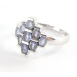 A dress ring, of layered design set with oval pale amethyst with three row central bar, and