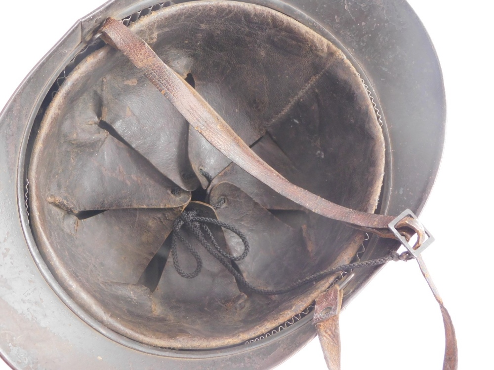 A French First World War metal helmet, with applied badge stamped RF and leather interior. - Image 2 of 2