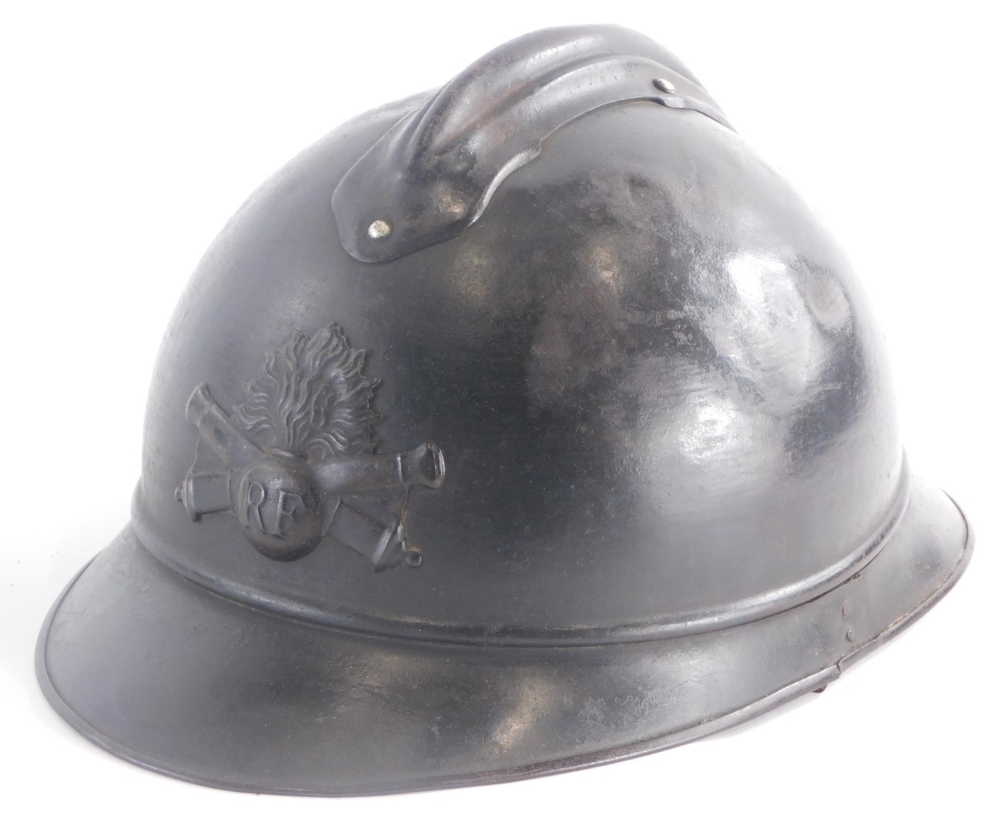 A French First World War metal helmet, with applied badge stamped RF and leather interior.