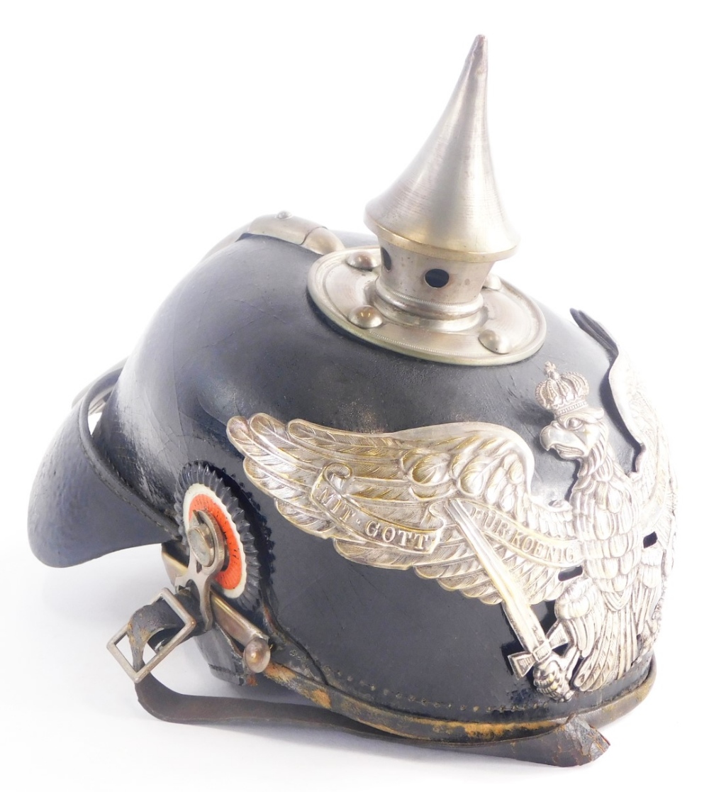 A German leather and silvered metal Pickelhaube helmet, with typical spiked top and badge bearing