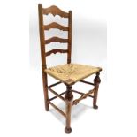 A Lincolnshire type ash ladder back chair, with a rush seat on cabriole legs.