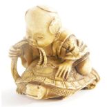 A Chinese carved netsuke, model in the form of a young boy seated on a turtle. (AF)