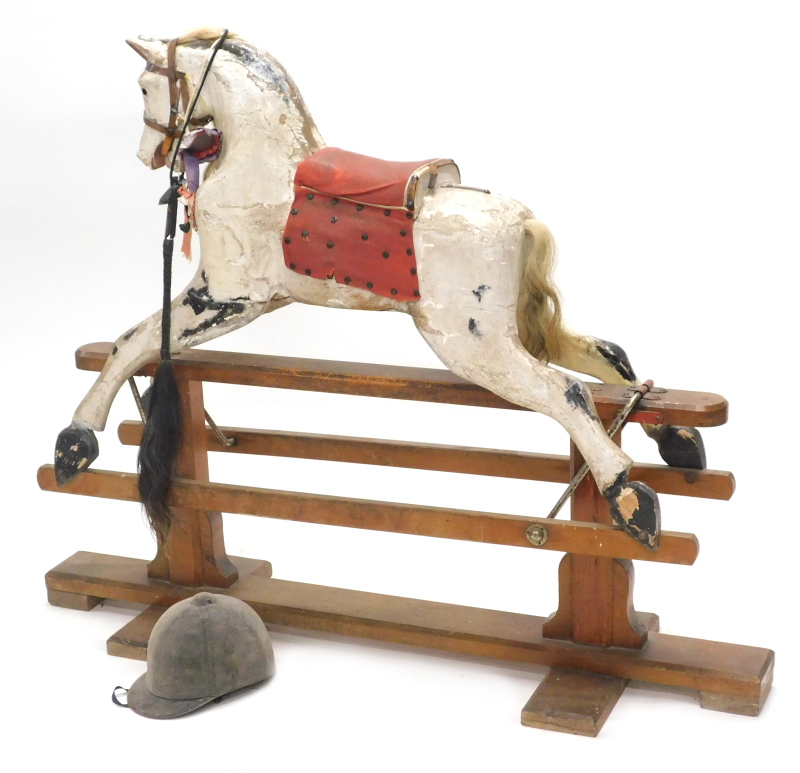 A Victorian dapple grey rocking horse, the pitch pine trestle stand with indistinct label, (AF),