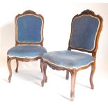 A pair of continental walnut dining chairs, each with a cartouche shaped carved padded back, a