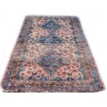 A Persian rug, with a central pole medallion in navy, on a red ground with multiple borders, 248cm x