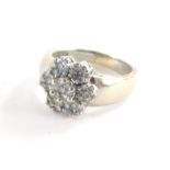 A diamond cluster ring, with six petal flower design, each set with seven round brilliant cut tiny