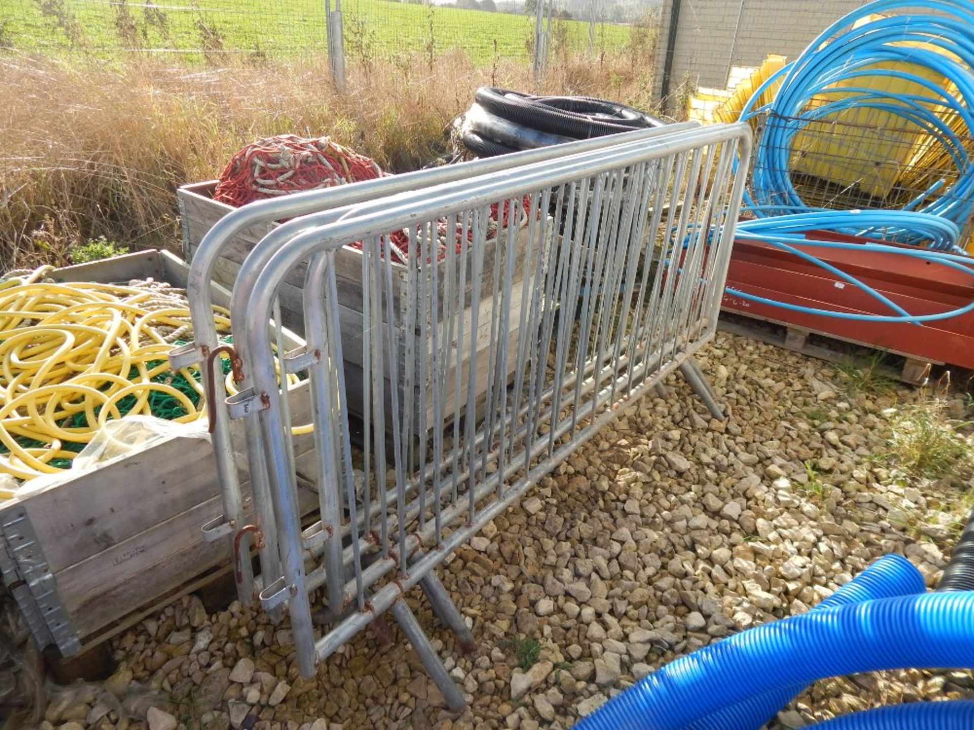 Nine galvanized steel pedestrian walkway barriers.