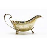 An Elizabeth II silver sauce boat, with a gadrooned border, shaped handle and three shell cast suppo