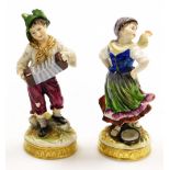 Two 19thC German porcelain figures, of a young boy with accordion and girl with tambourine, on circu