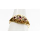 An 9ct gold Victorian style dress ring, the centre set with three garnets and four diamonds (one mis