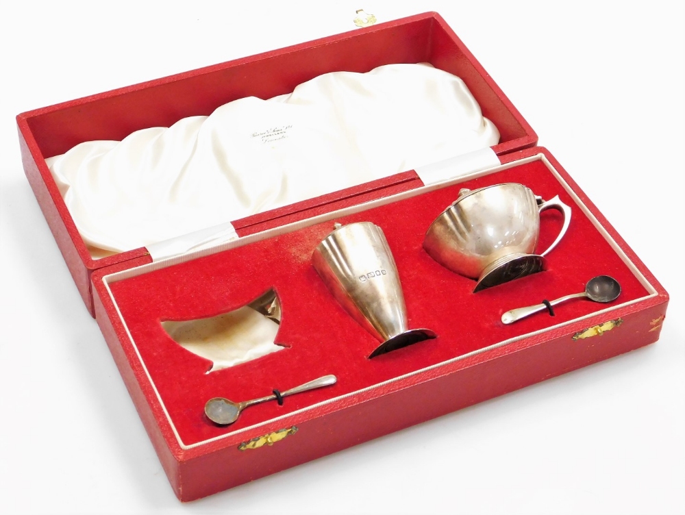 An Elizabeth II silver part cruet, the mustard pot and pepper pot with urn shaped finials and shaped
