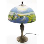 A Thomas Kinkade table lamp, the reverse decorated shade decorated with a field and cottage scene, o