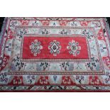 A Shiraz red ground rug, decorated with three central gulls, in repeating floral borders, 264cm x 19