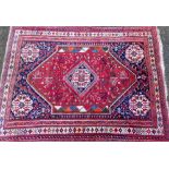 A Caucasian red and blue ground rug, the central medallion in a surround of flowers of dog tooth dec