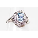 A platinum aquamarine and diamond ring, the central oval aquamarine in rub over setting, surrounded