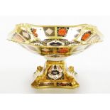 A Royal Crown Derby porcelain Imari pattern pedestal bowl, the top with a shaped border, on a square