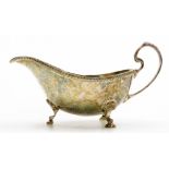 An Elizabeth II silver sauce boat, with a gadrooned border, shaped handle and three shell cast suppo