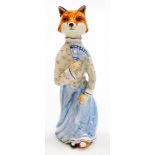 A Rye pottery fox figure, of a female fox in blue and white dress with fan, marked VH, 23cm high.