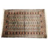 A Tekke turquoise ground rug, decorated with two rows of fourteen guls, within repeating geometric b