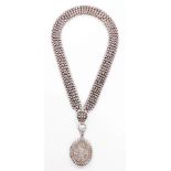 A Victorian pendant and chain, the oval pendant with leaf decoration and outer beaded detailing, whi