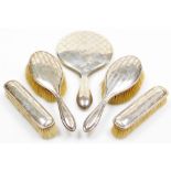 A George V silver mounted dressing table set, comprising two hair brushes, two clothes brushes and a