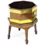 An early 19thC mahogany and brass bound wine cooler, of octagonal form, with a galvanised tin, lion