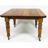 An early Edwardian walnut extending dining table, the canted top raised on heavy reeded tapering leg