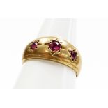 A 9ct gold three stone set dress ring, set with three rubies each in star setting, ring size S½, 3.7