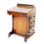 A Victorian walnut and marquetry inlaid Davenport, the hinged lid enclosing a fitted interior for pe