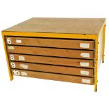 A plan chest, with applied pine effect plywood top, on yellow metal supports, with chipboard sides,